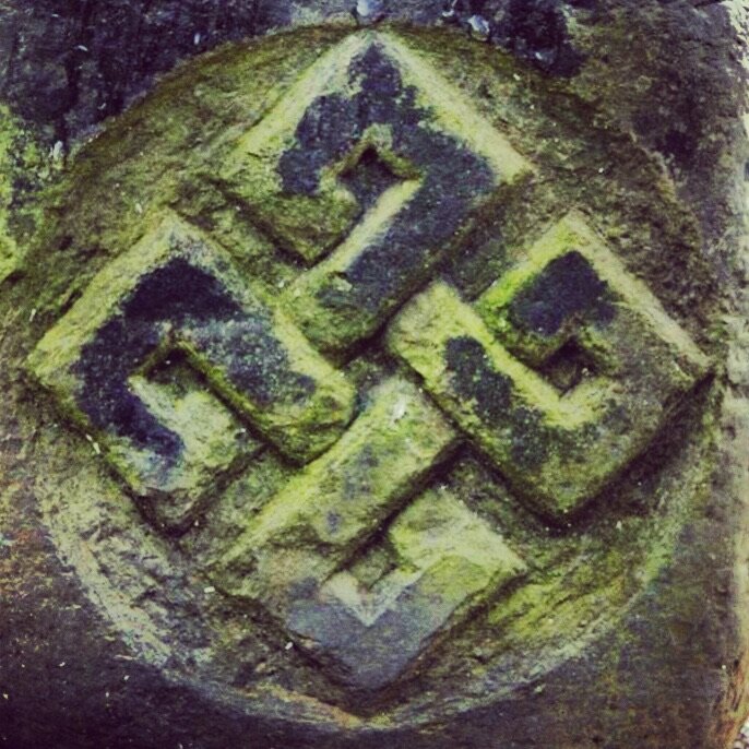 Carved knotwork medallion, weathered with moss