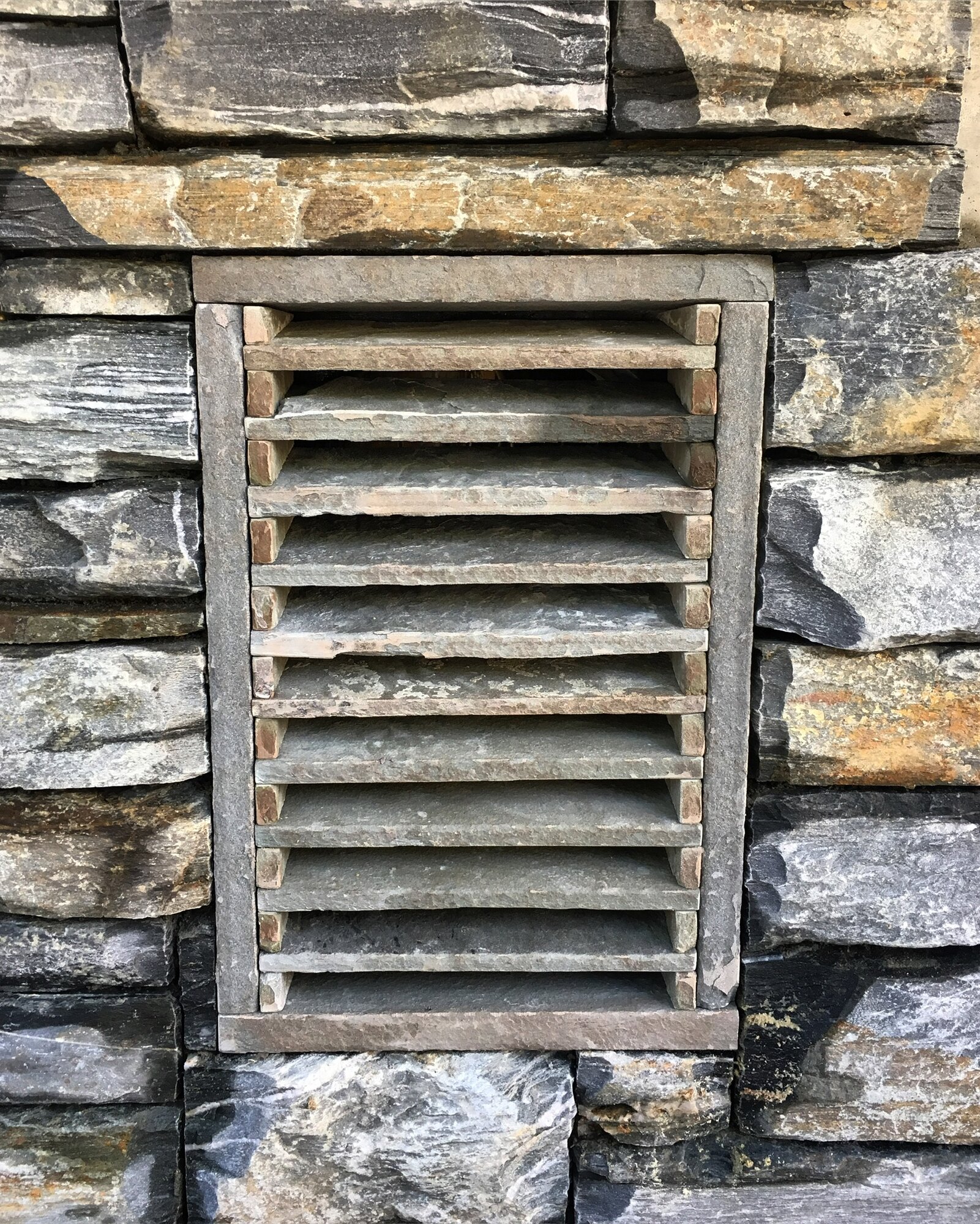 Custom stone vent grate with a slate surround