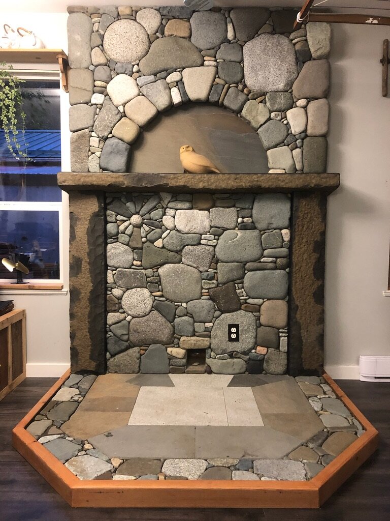 Arched pebble mosaic fireplace with a hexagonal hearth