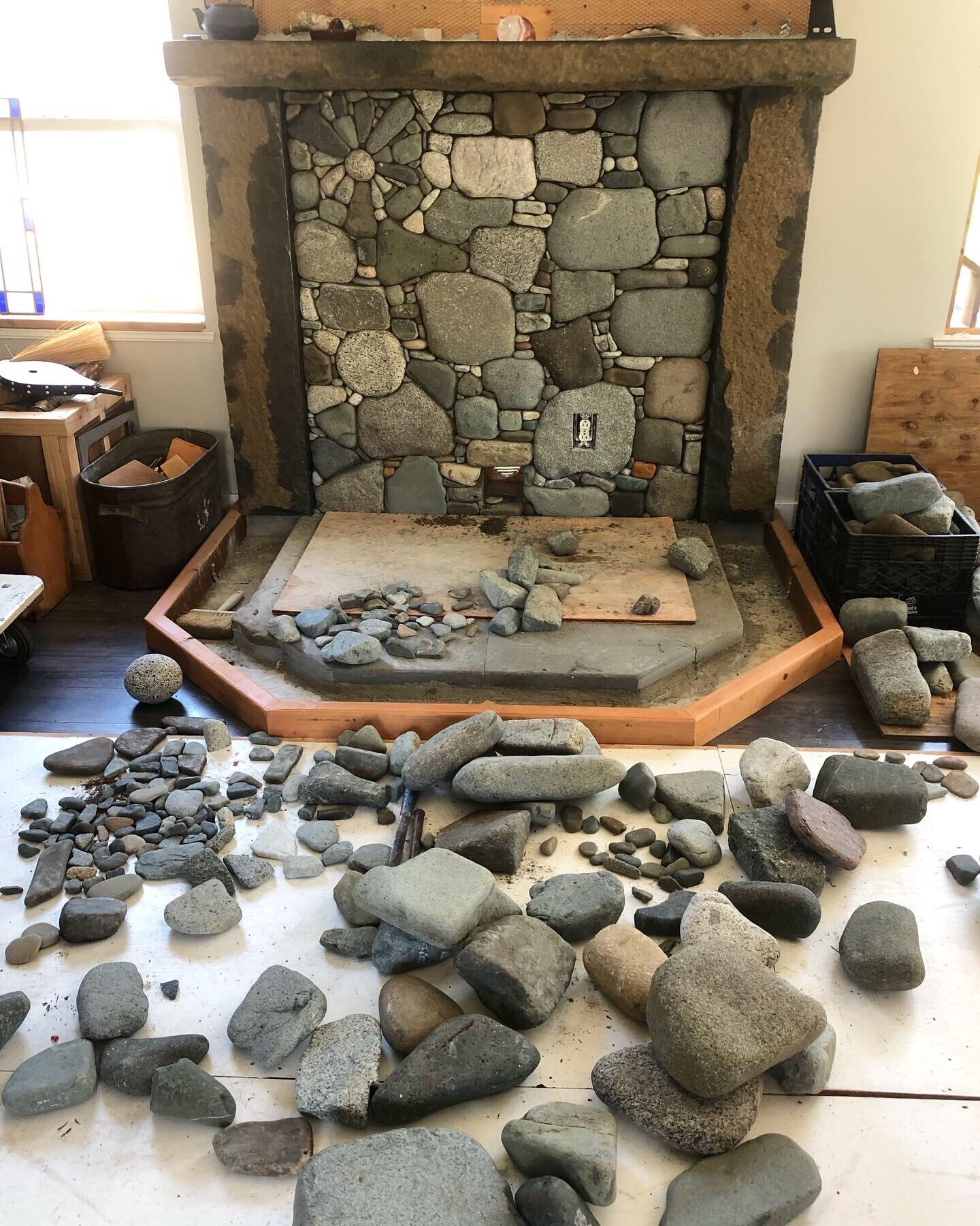 Pebble mosaic fireplace hearth being built, stones laid out