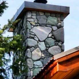 Exterior river rock chimney with a copper cap