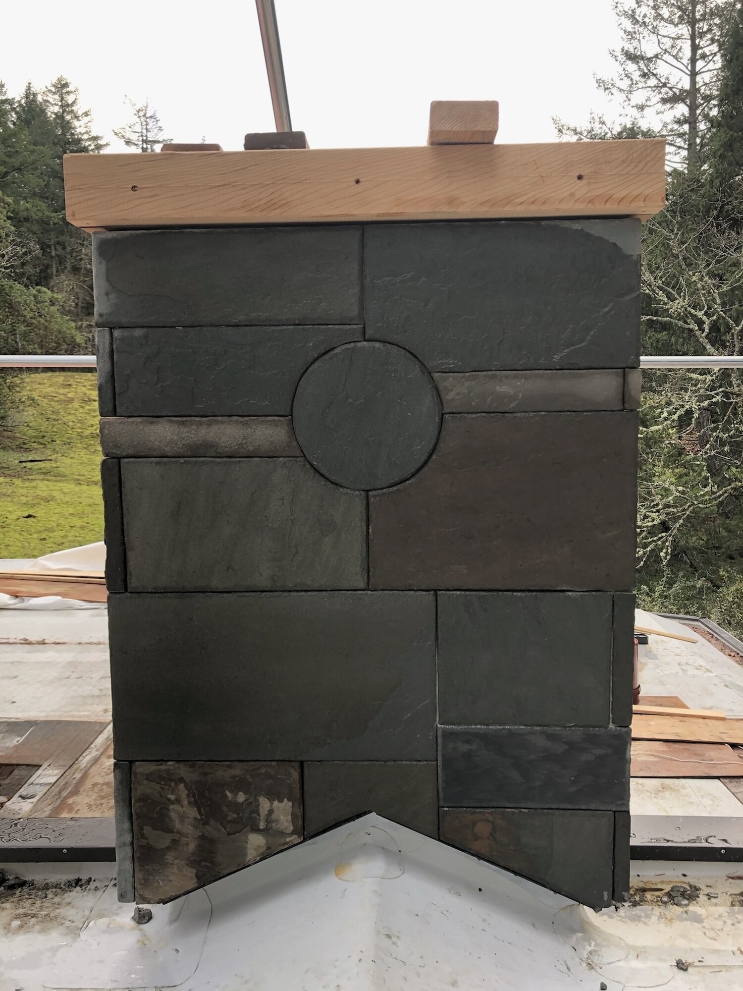 Slate chimney cap with a geometric circle motif
