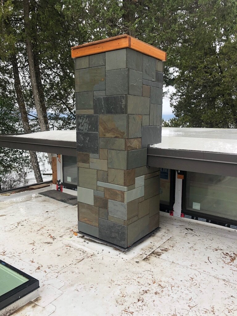 Exterior slate chimney with a cedar cap
