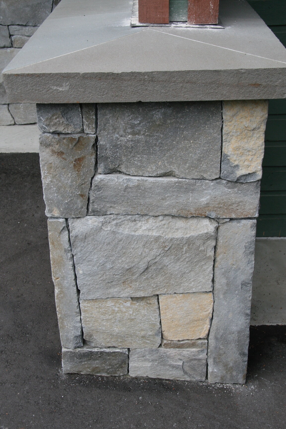 Dry-stack fieldstone pillar with a bluestone cap