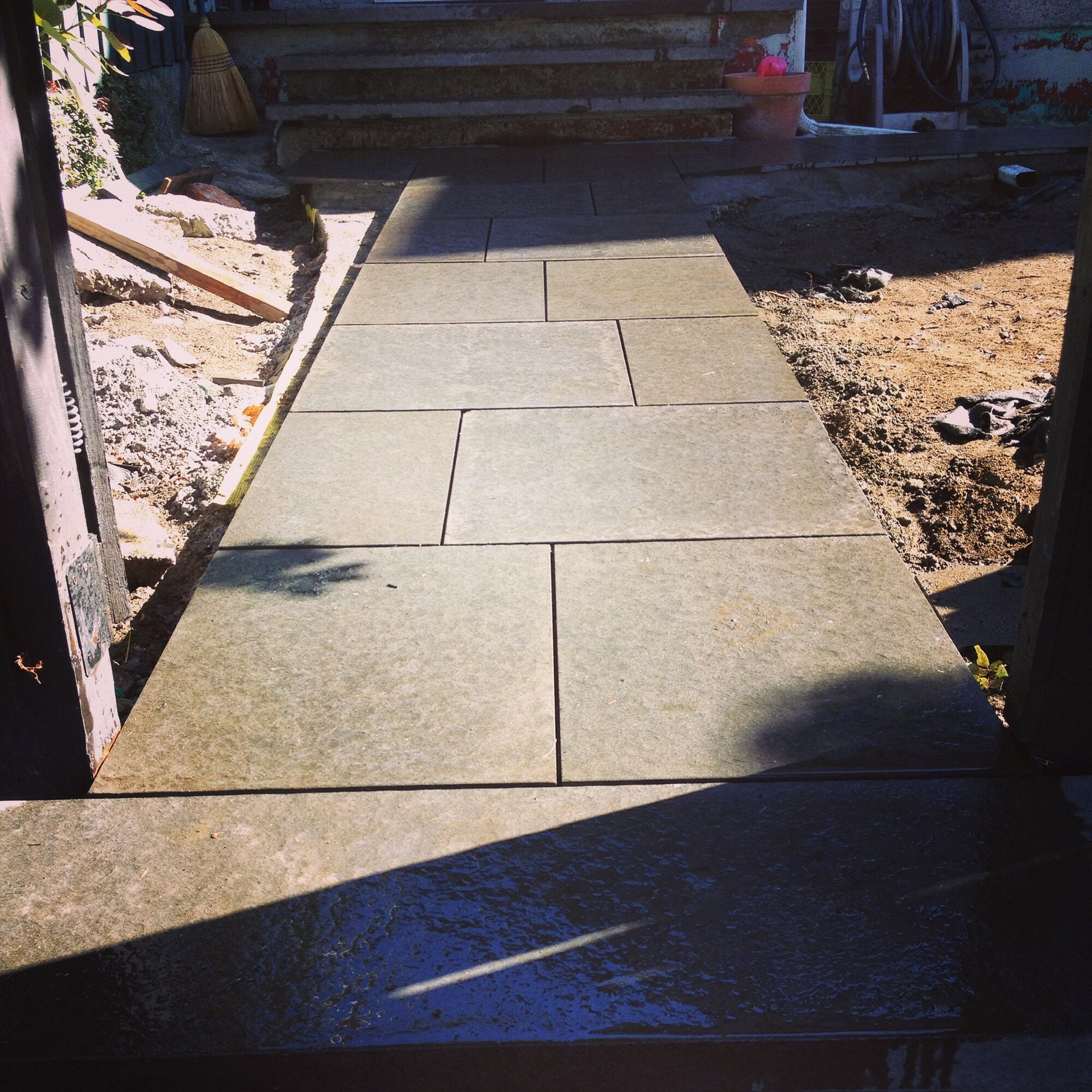 Dry-stack stone steps beside a herringbone brick landing
