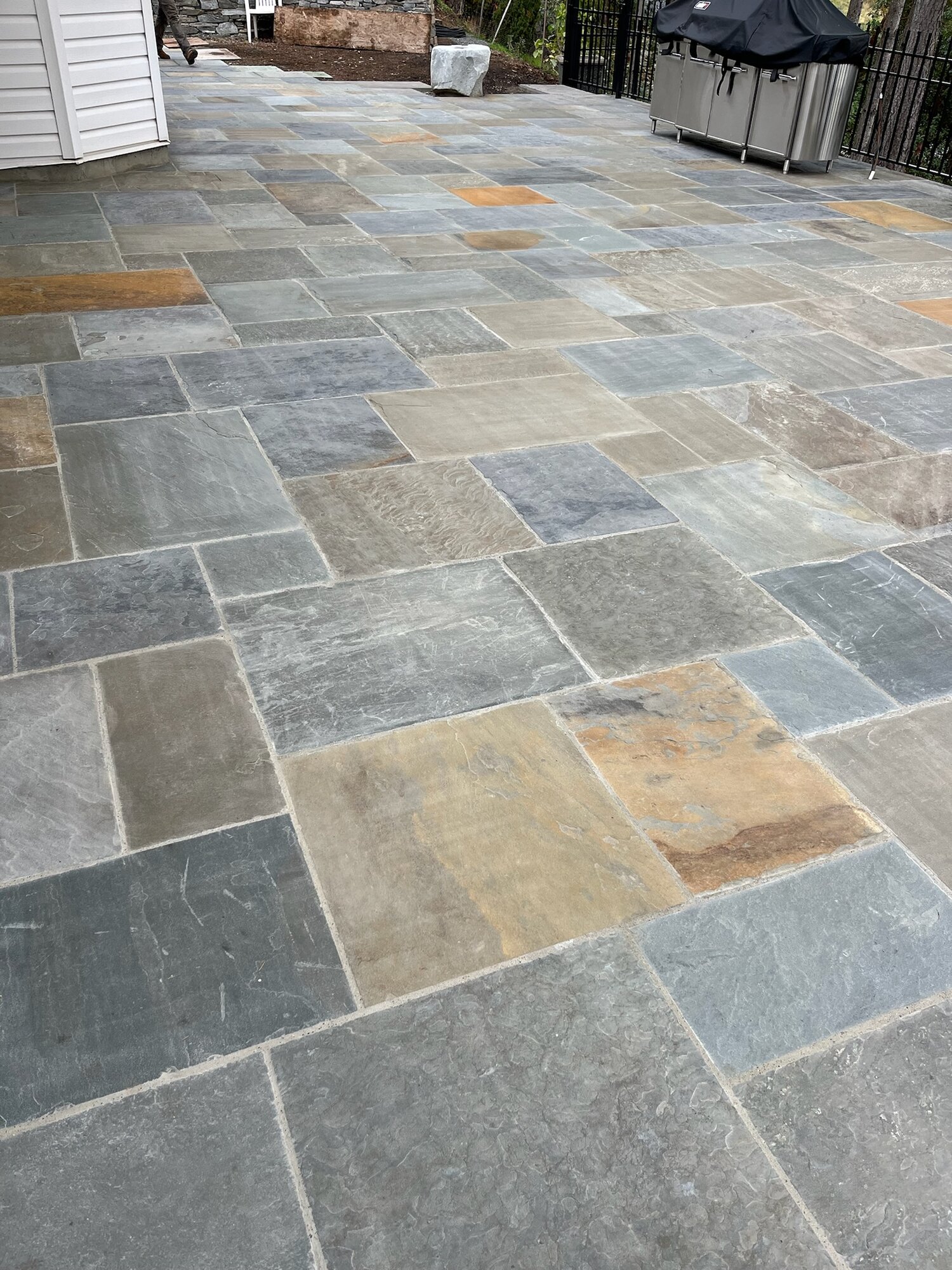 Large flagstone patio with mixed warm and cool tones, BBQ area