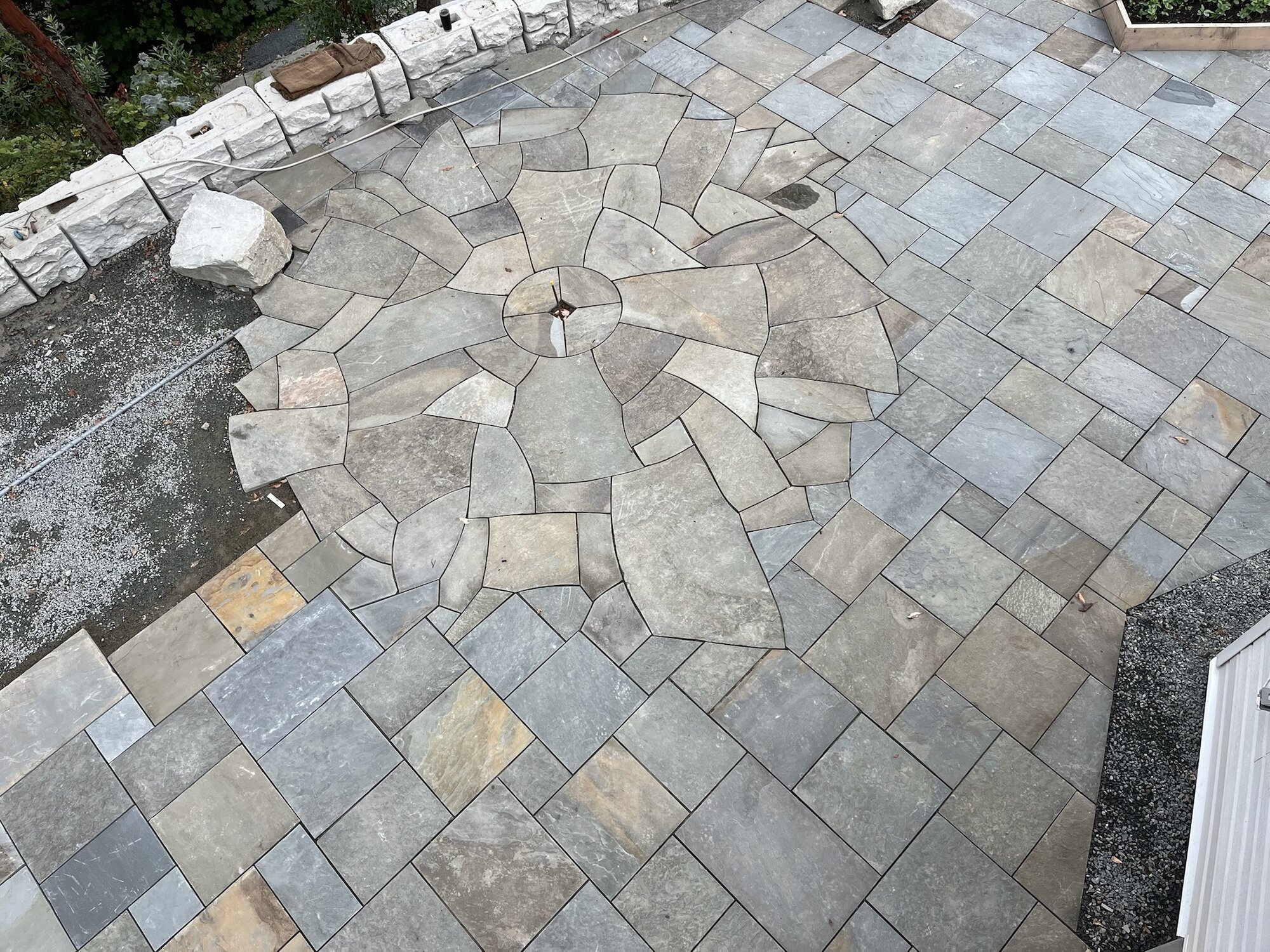 Aerial view of a flagstone patio with a radial medallion center pattern
