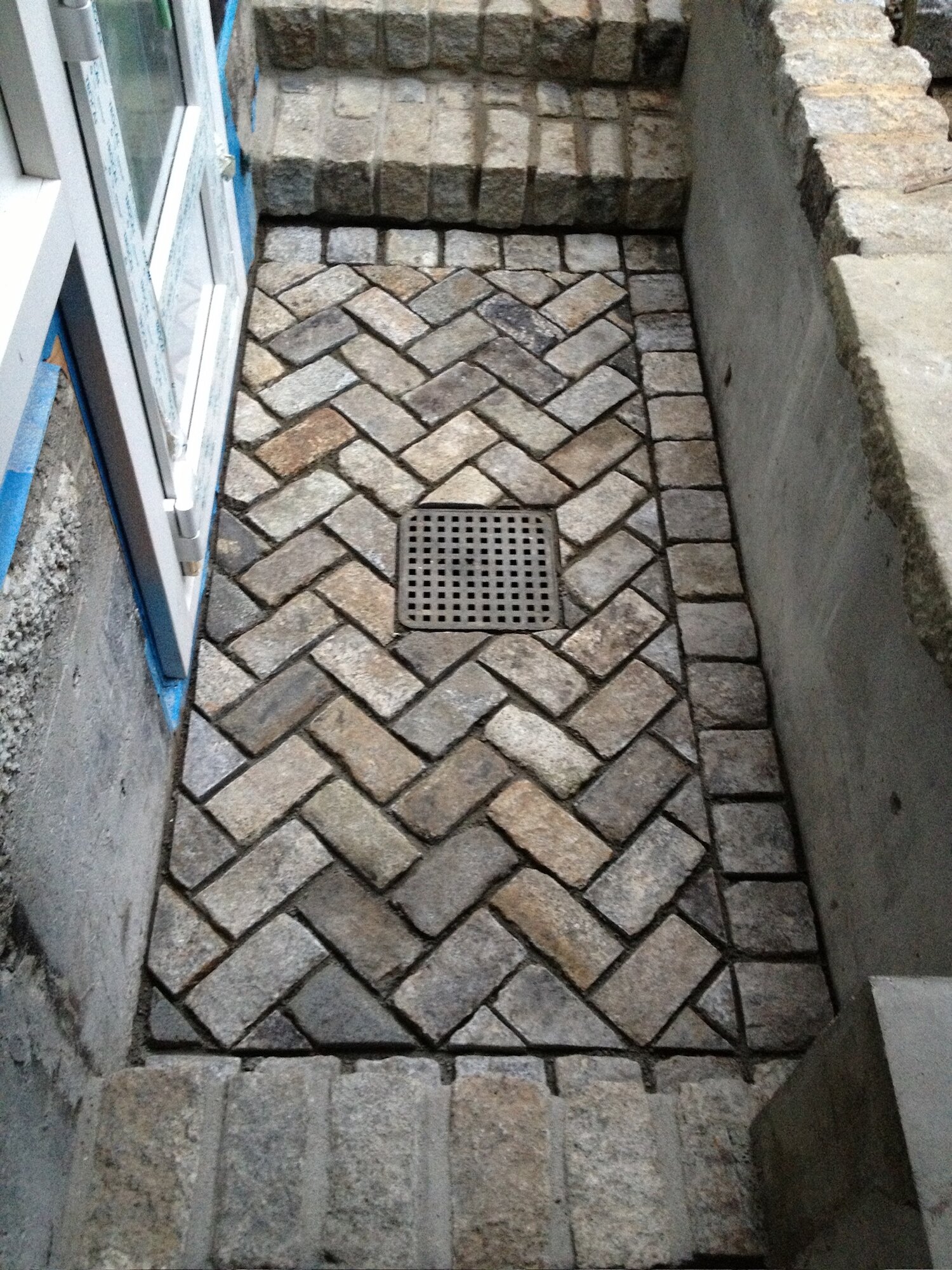 Herringbone brick walkway leading to a stairwell
