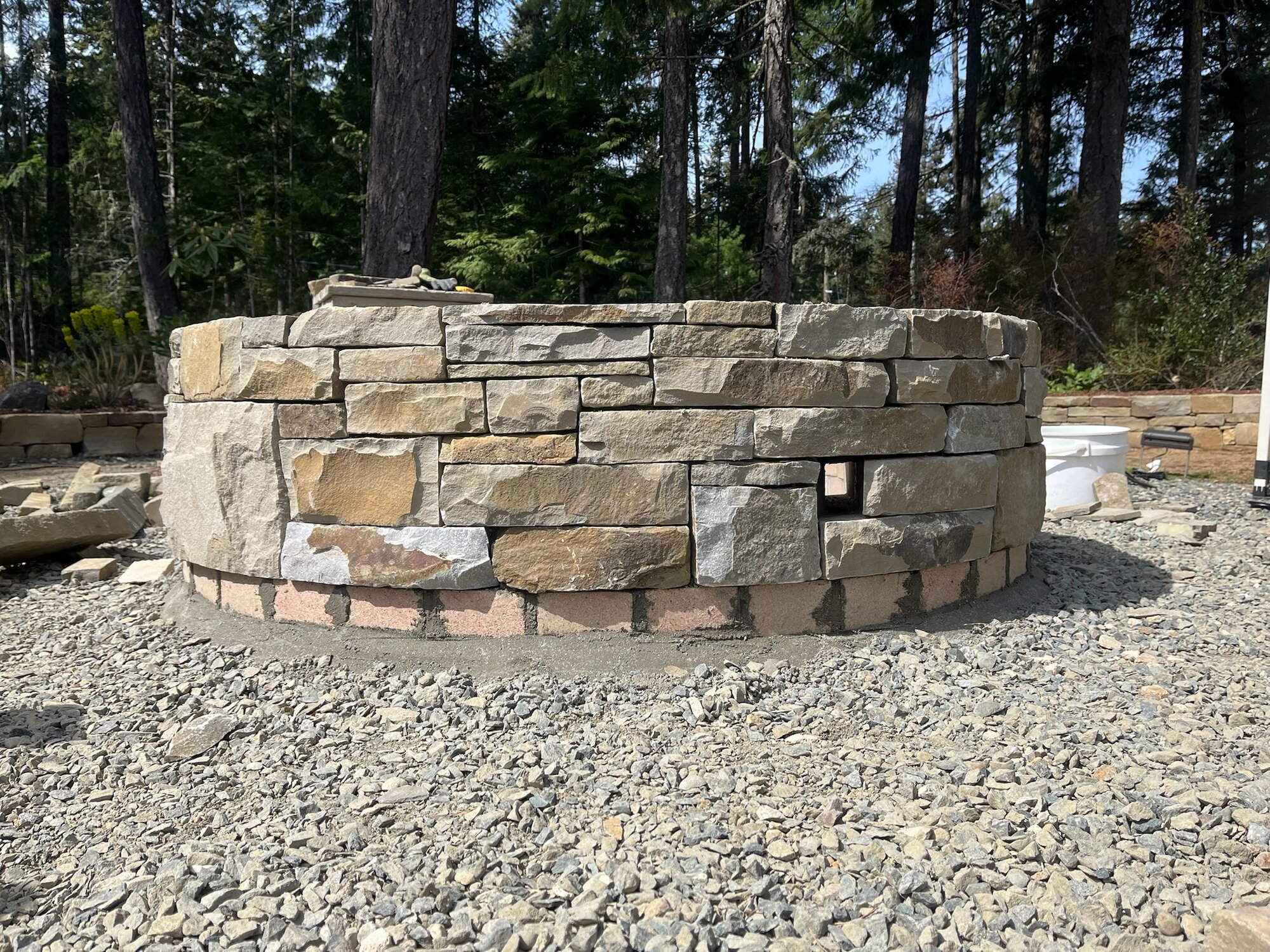 Curved fieldstone wall under construction