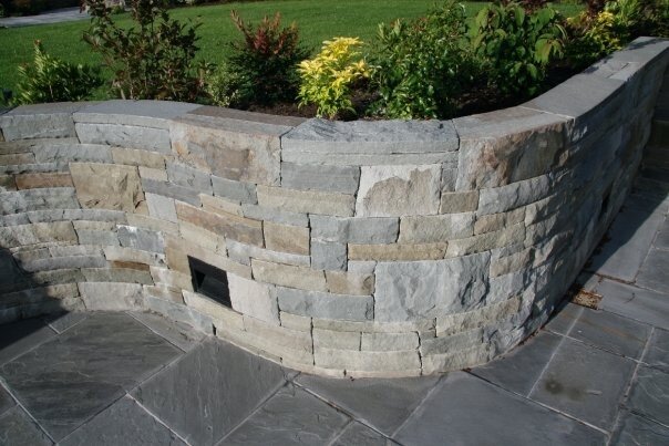 Curved stone planter wall bordering a garden