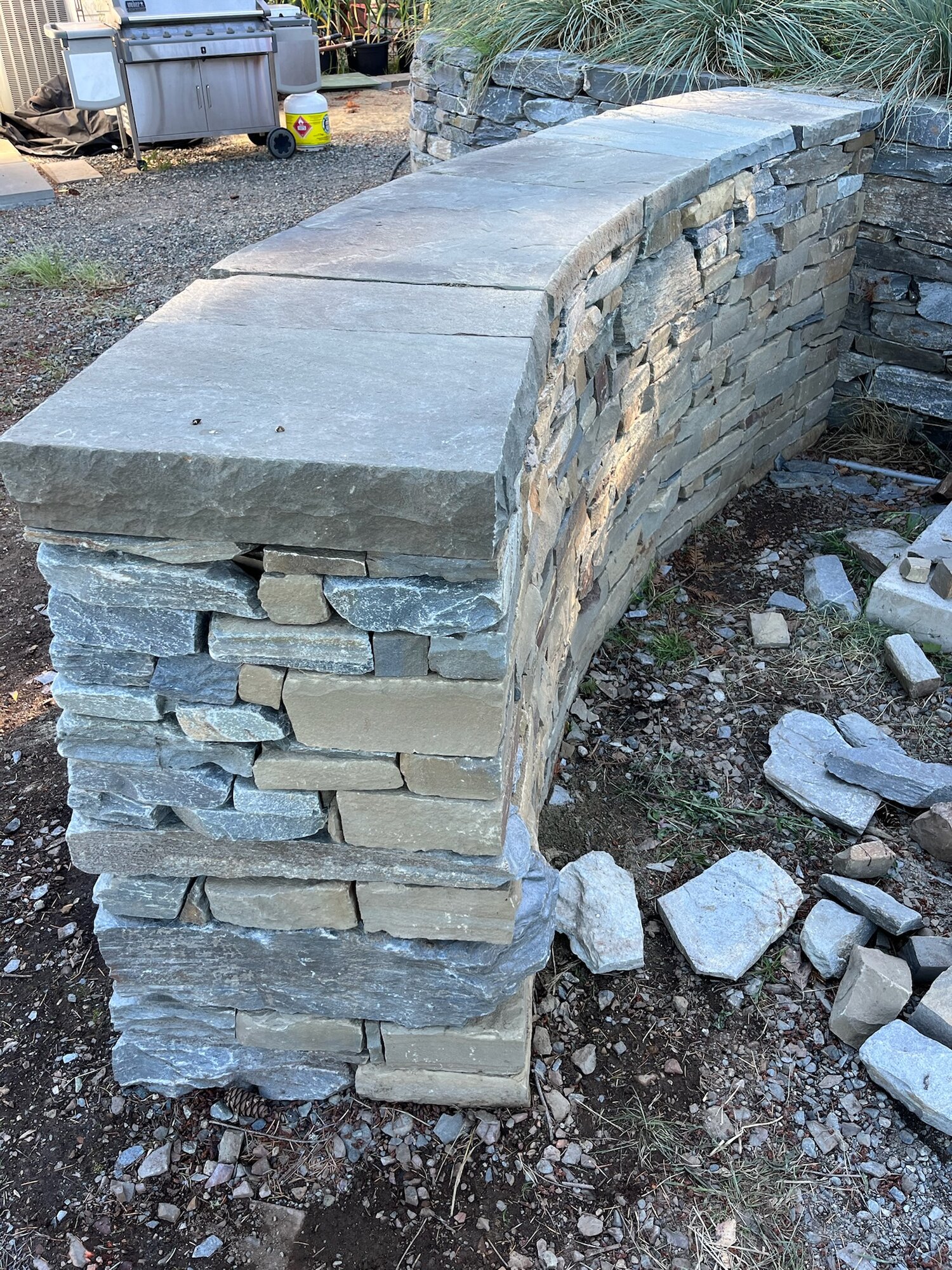 Close-up corner detail of a curved dry-stack wall under construction