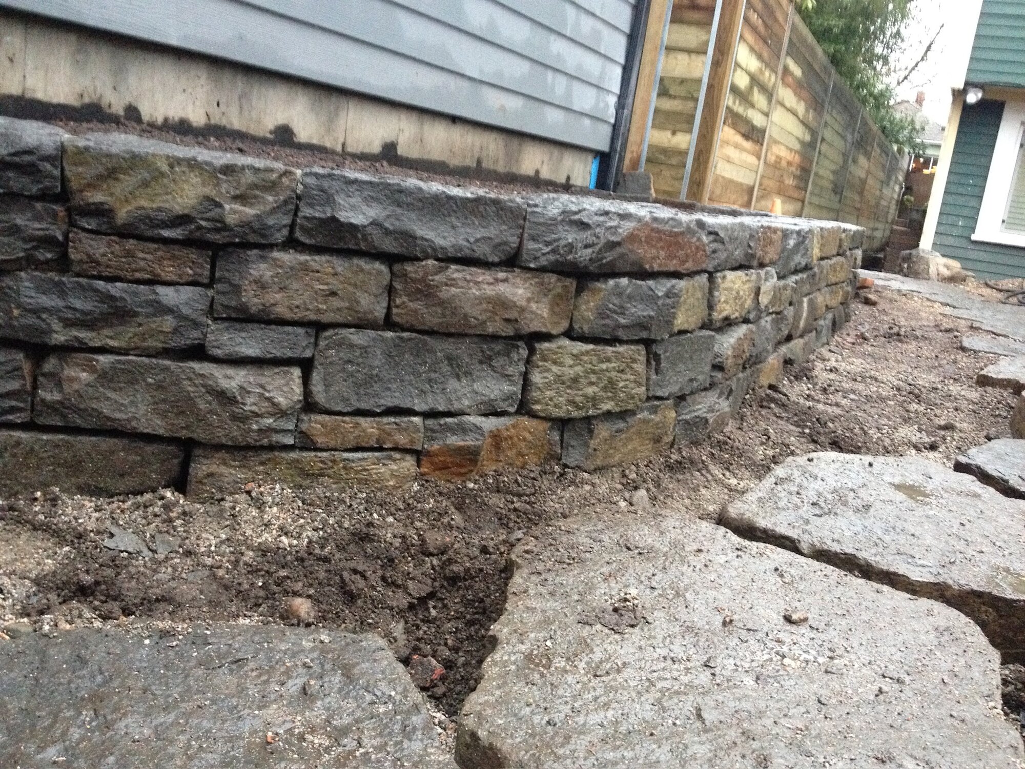 Dry-stack fieldstone retaining wall along a side alley