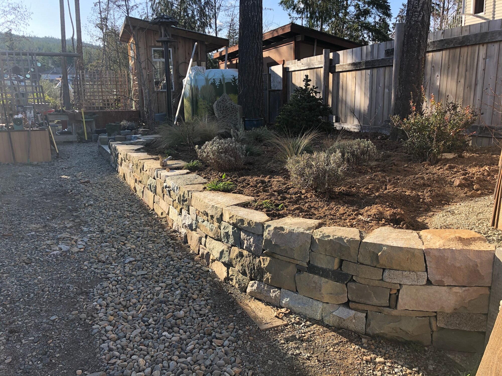 Fieldstone retaining wall along a garden path