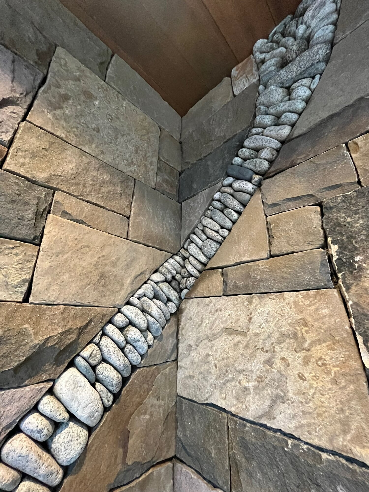 Detail of a pebble inlay stripe in a flagstone wall