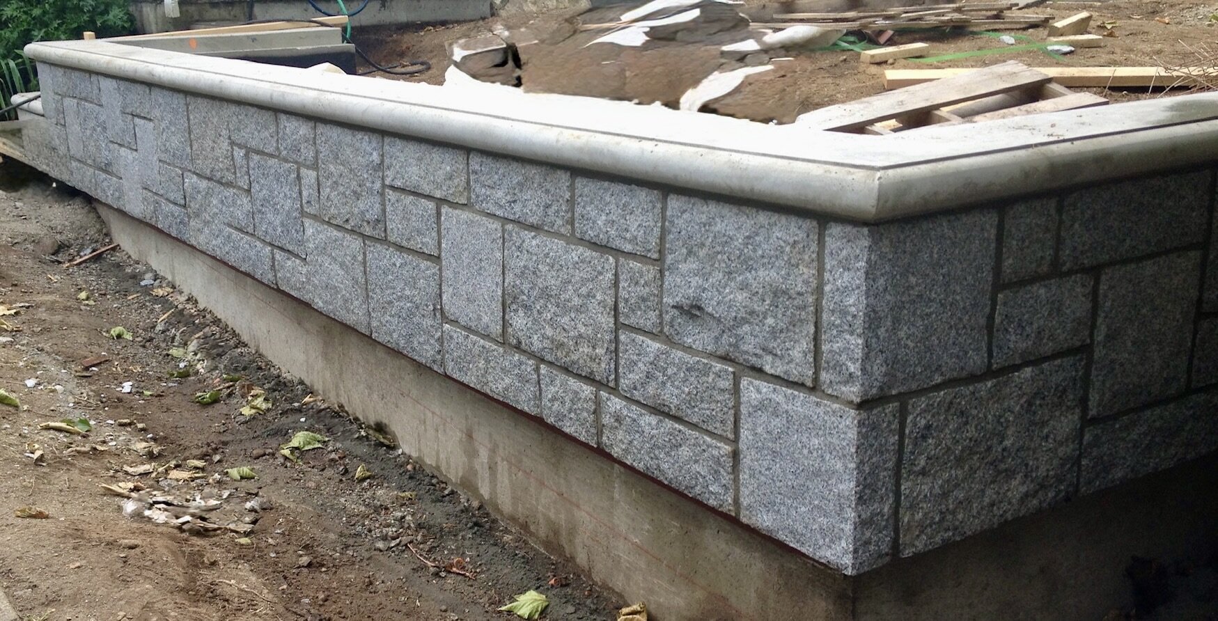 Granite-capped fieldstone retaining wall corner