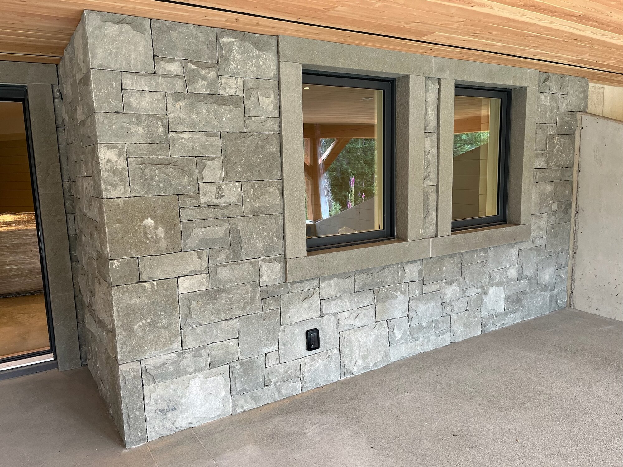 Interior stone wall with double window surround and cedar ceiling
