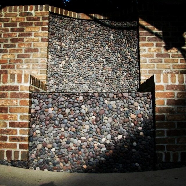 Pebble mosaic panel set in a brick surround