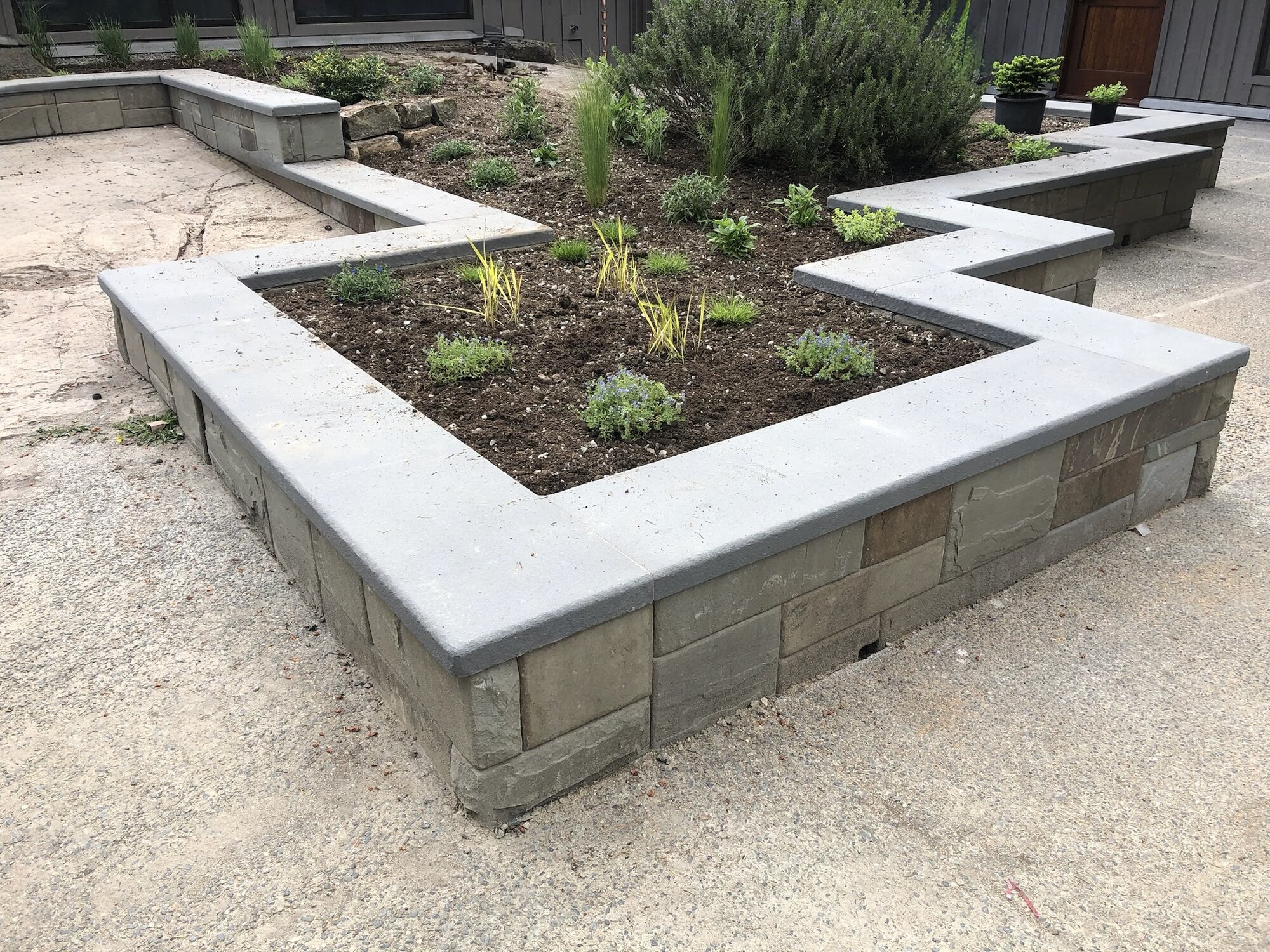 Zigzag stone planter wall around a garden bed