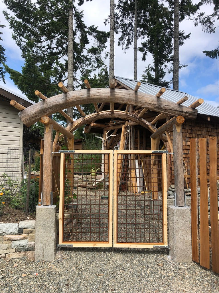 Hand-built log entry arch with wire gate